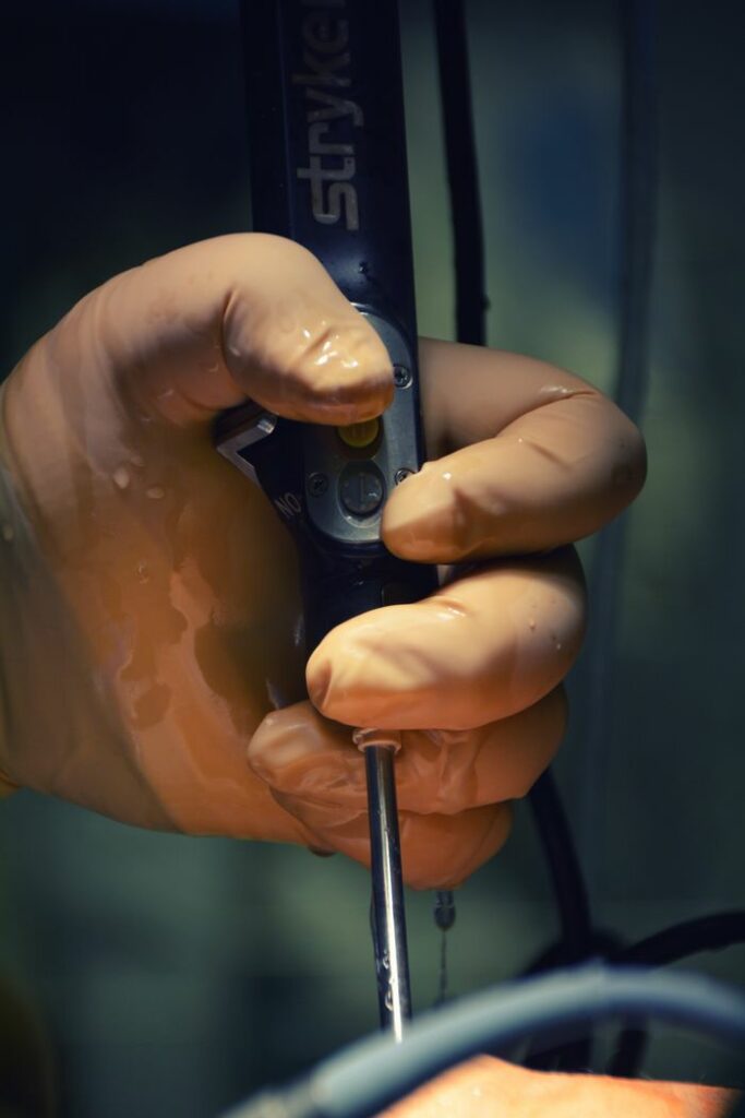 Close-up of a surgeon's gloved hand holding a surgical tool during an operation.